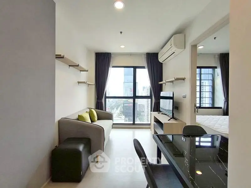 Modern living room with city view, featuring sleek furniture and large windows.