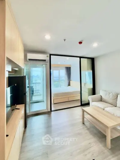 Modern living room with glass partition, cozy sofa, and view of bedroom and balcony.