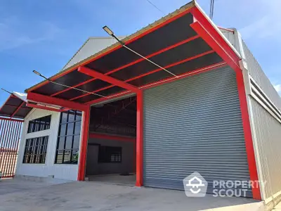 Spacious industrial warehouse with modern red steel frame and large roller door