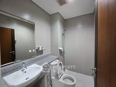 Modern bathroom with sleek fixtures and neutral tiles, featuring a spacious layout and contemporary design.