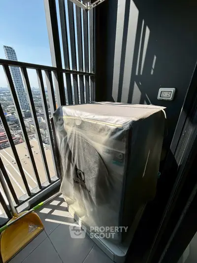 High-rise balcony with city view and covered washing machine, perfect for urban living.