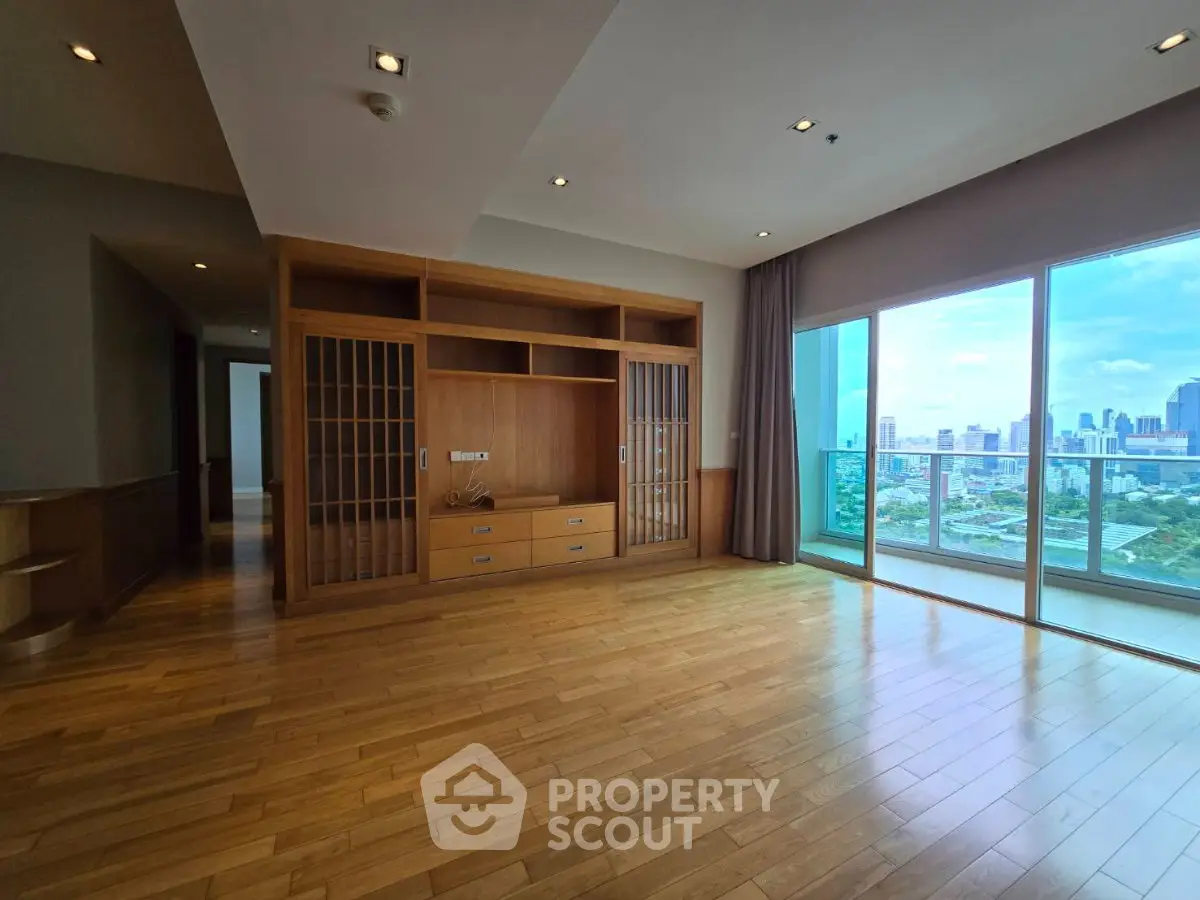 Spacious living room with wooden flooring and city view balcony