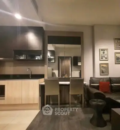 Modern open-layout kitchen and living area with stylish decor and cozy seating.