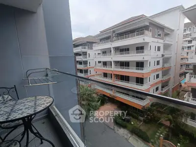 Charming balcony view of modern apartment complex with stylish outdoor furniture.