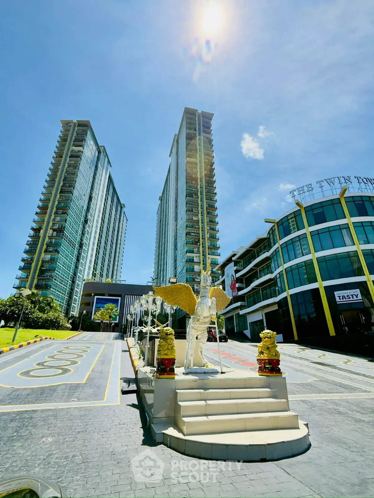 Stunning twin towers with modern architecture and elegant entrance under a bright blue sky.