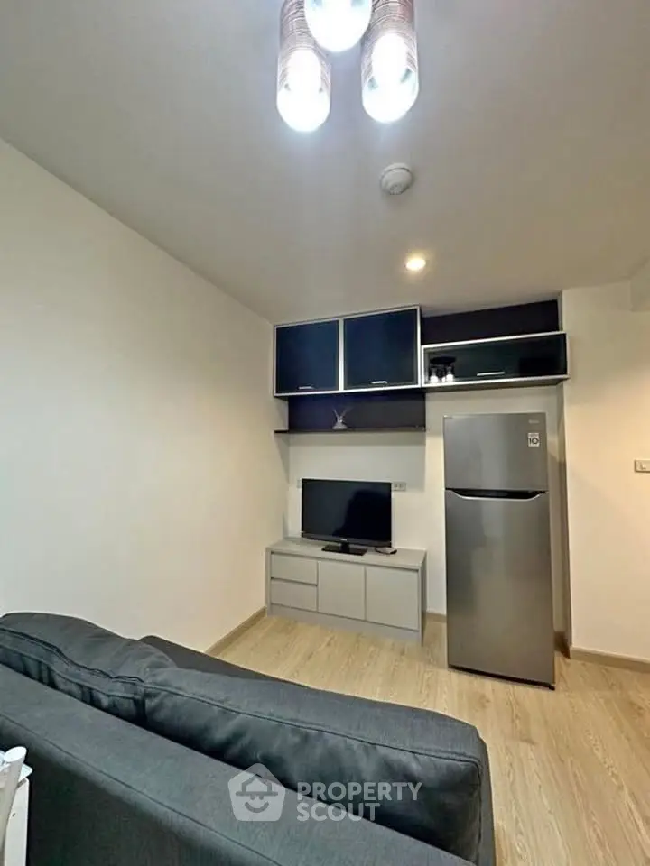 Modern living room with sleek furniture and stainless steel fridge