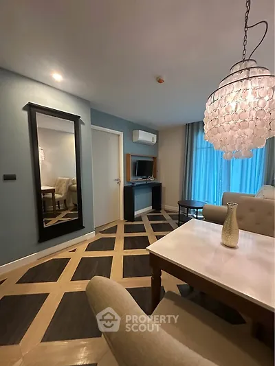 Stylish living room with elegant chandelier and modern decor in a contemporary apartment.