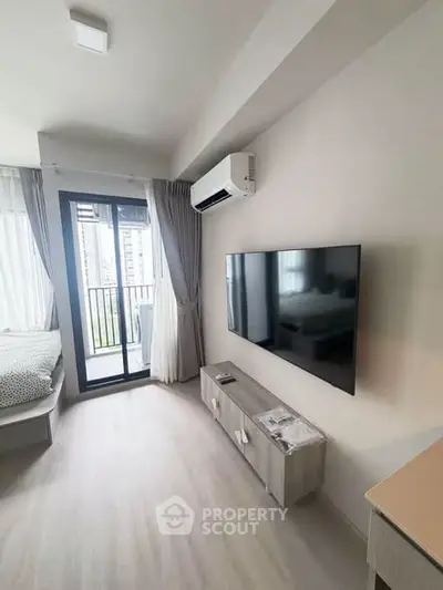 Modern bedroom with balcony access and wall-mounted TV in a stylish apartment.