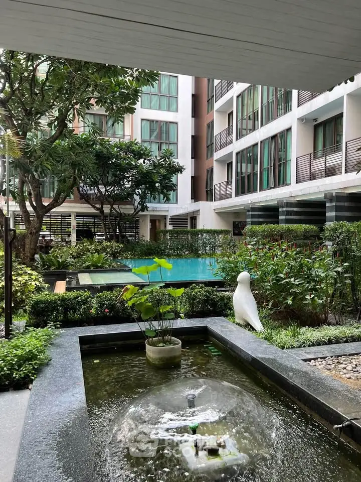 Modern apartment complex with lush garden and serene pool view