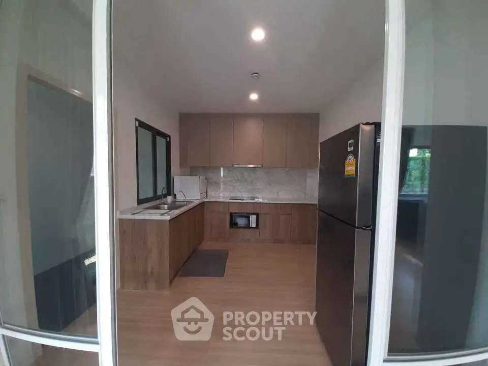 Modern kitchen with sleek cabinets and stainless steel appliances in a stylish apartment.