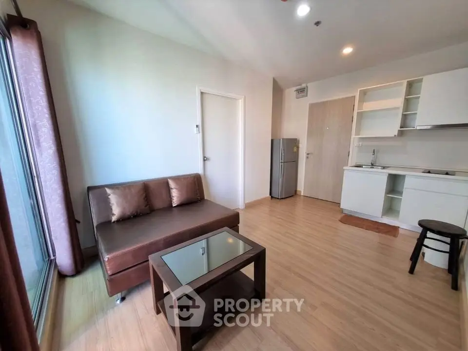 Modern living room with sleek furniture and open kitchen layout in a stylish apartment.