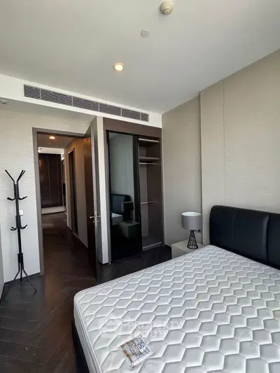 Modern bedroom with sleek design and ample natural light in luxury apartment.