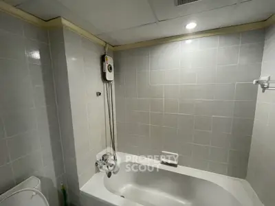 Modern bathroom with bathtub and shower in a tiled setting