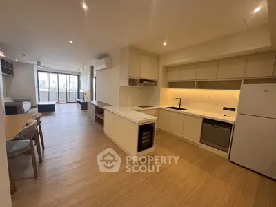 Spacious modern kitchen with open layout and elegant living area, featuring sleek appliances and ample natural light.