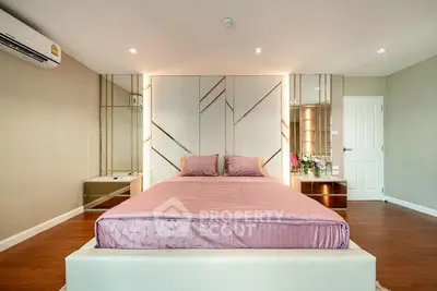 Luxurious bedroom with elegant decor and modern design, featuring a stylish bed and mirrored accents.