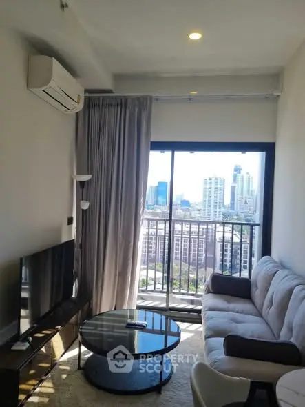 Modern living room with city view, featuring cozy sofa and sleek decor.