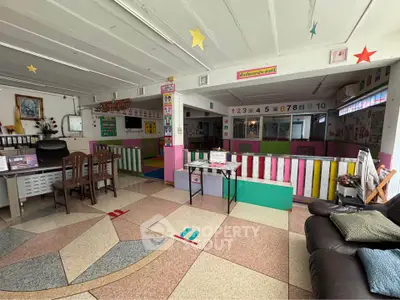 Spacious daycare center with colorful decor and ample seating, perfect for children's activities and learning.