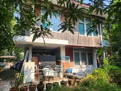 Charming two-story wooden house with lush greenery and ample outdoor space