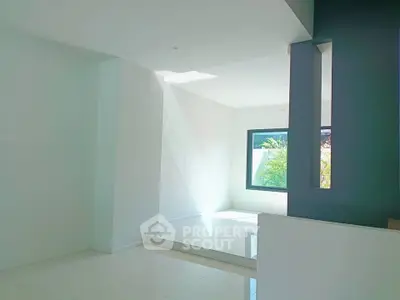 Bright and spacious modern interior with large window and sleek design.