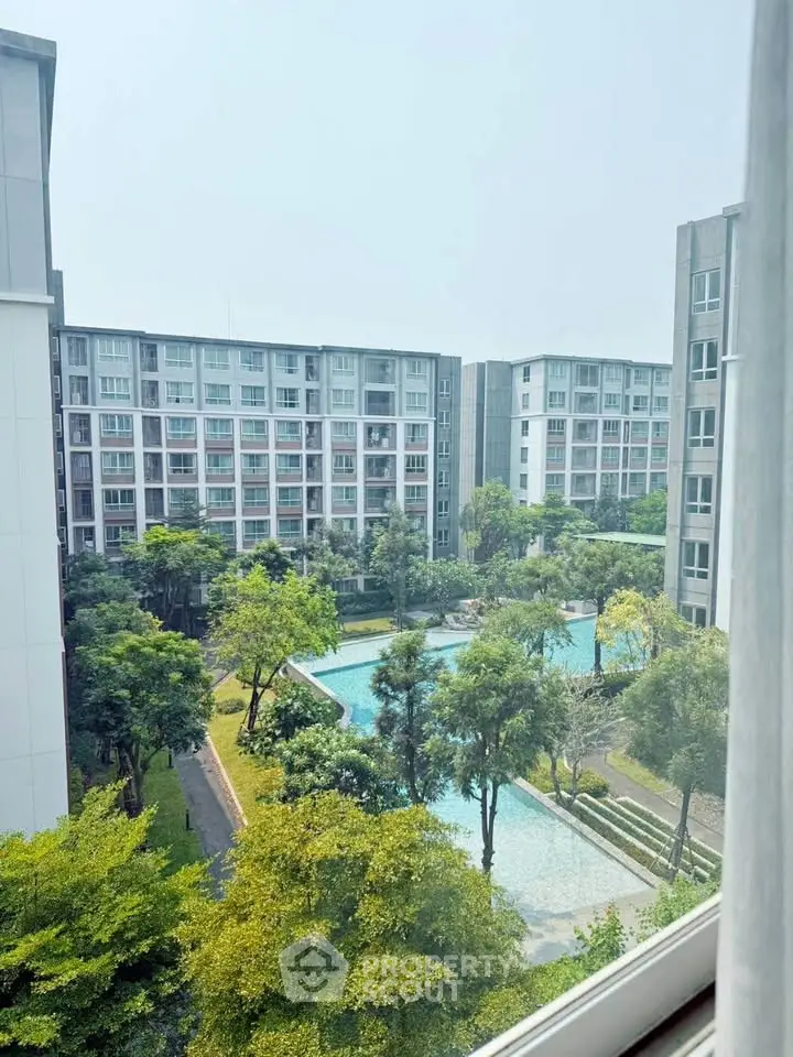 Modern apartment complex with lush gardens and swimming pool view