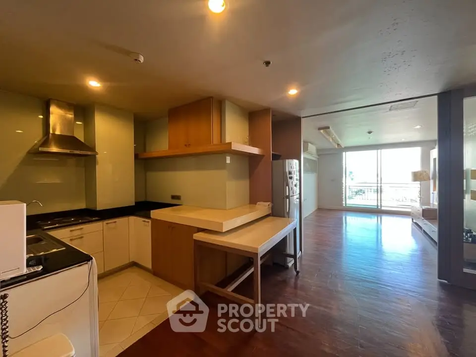 Spacious open-layout kitchen and living area with modern appliances and large windows offering natural light.