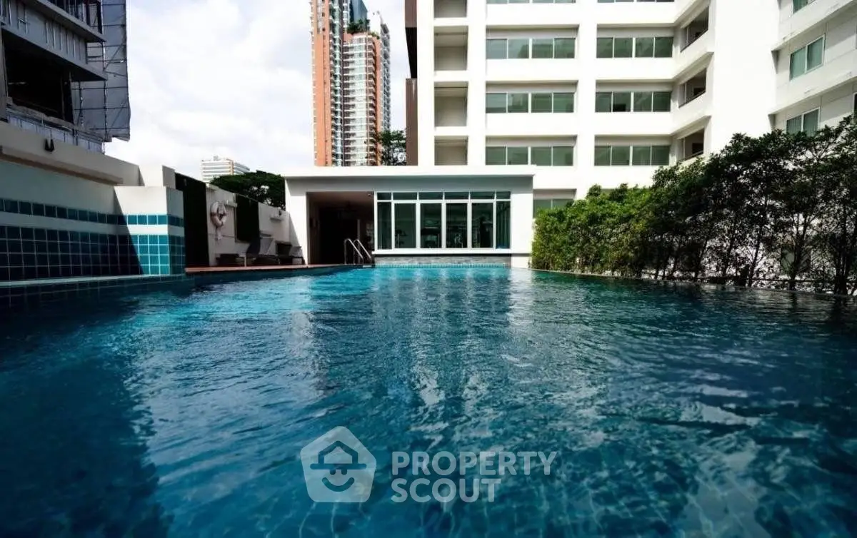 Luxurious condominium with a stunning outdoor pool and modern architecture.