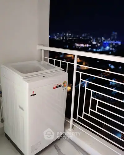 Modern balcony with washing machine and stunning city night view.