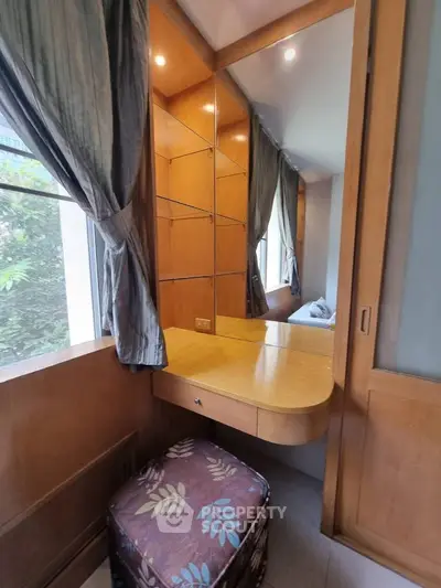 Cozy bedroom corner with built-in wooden vanity and natural light