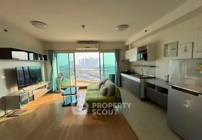 Spacious modern living room with open kitchen and city view, featuring stylish decor and ample natural light.
