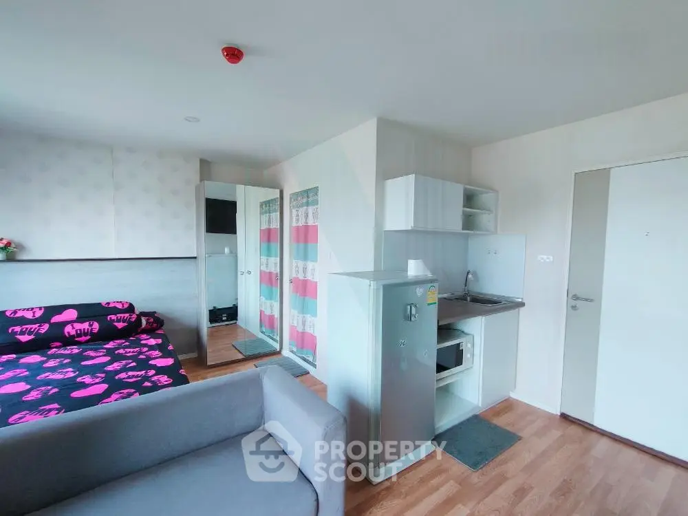 Modern studio apartment with cozy living area and compact kitchen