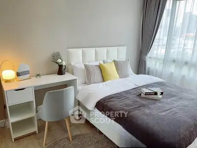 Modern bedroom with stylish decor, cozy bed, and natural light from large window.