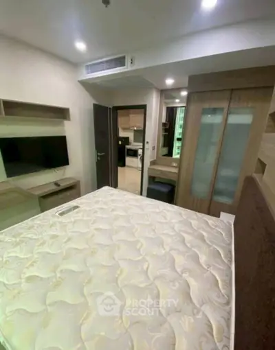 Cozy bedroom with modern furnishings and built-in storage in a stylish apartment.