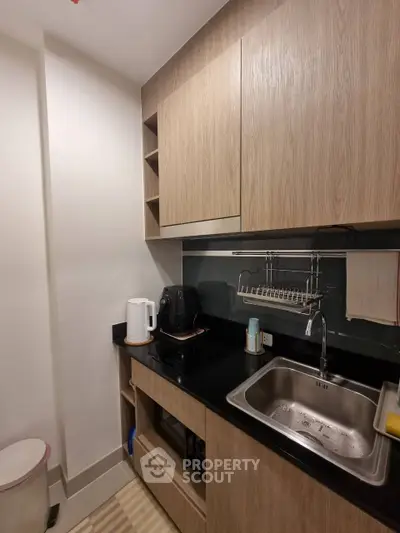Modern kitchen with sleek cabinetry and stainless steel sink in compact design.