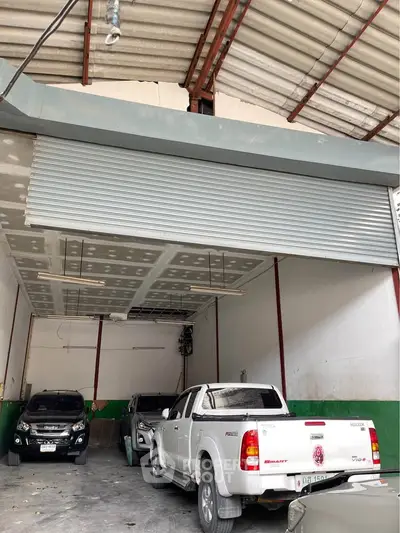 Spacious garage with multiple vehicles and high ceiling, ideal for storage or workshop use.