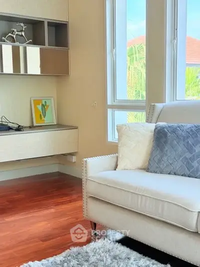 Cozy living room with modern decor and large windows offering natural light.