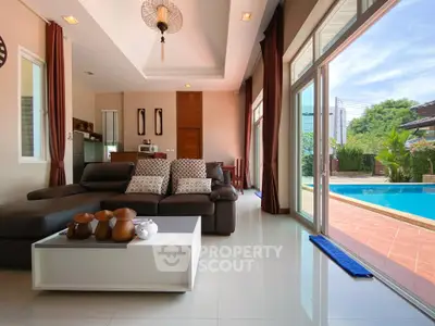 Luxurious living room with pool view, elegant decor, and abundant natural light.
