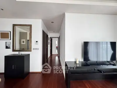 Modern living room with sleek wooden flooring and stylish TV setup