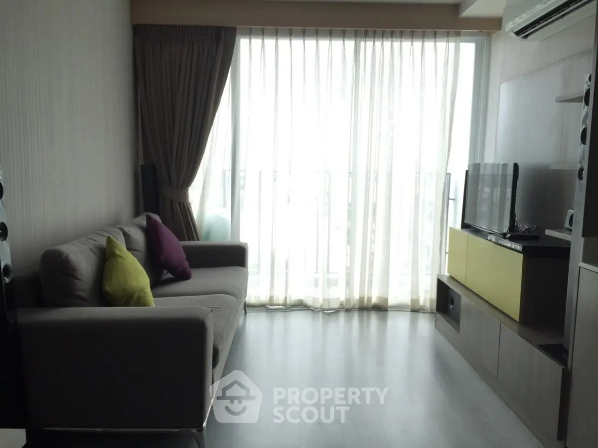 Modern living room with large window and stylish furniture in a cozy apartment.