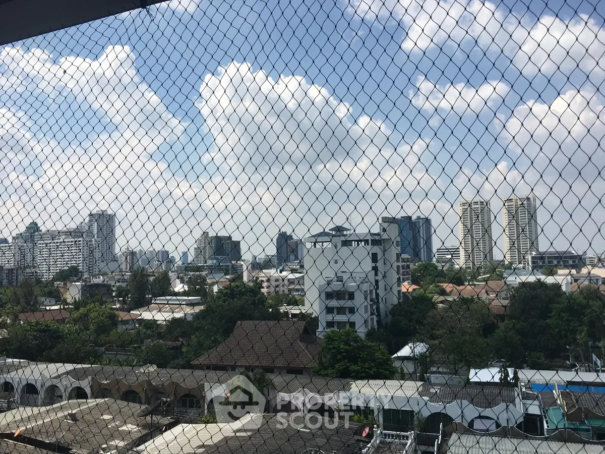 Stunning cityscape view from a high-rise balcony with lush greenery and skyline.