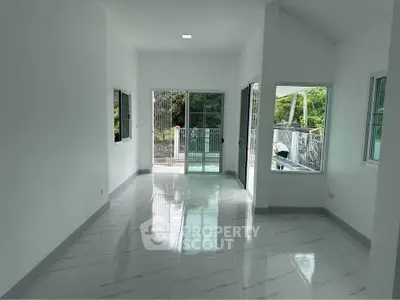 Spacious modern living room with large windows and glossy tile flooring