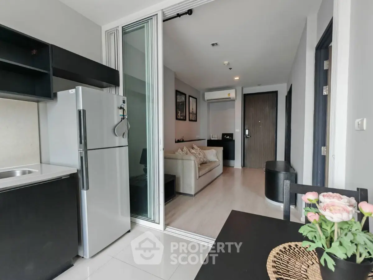 Modern open-plan apartment with sleek kitchen and cozy living area, perfect for urban living.