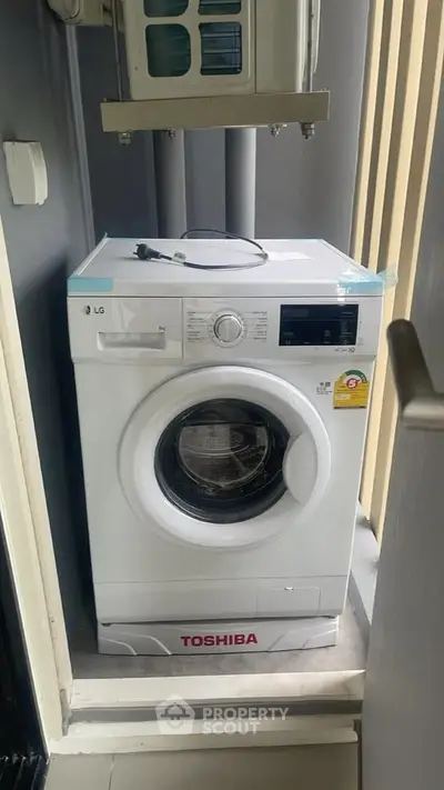 Compact laundry area with modern washing machine in sleek design.