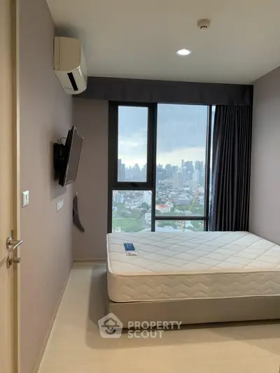Modern bedroom with city view, featuring a wall-mounted TV and air conditioning.