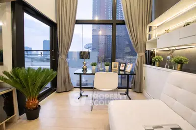 Modern living room with large windows and city view, featuring stylish decor and natural light.