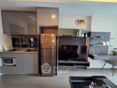 Modern kitchen and living area with sleek cabinetry and stainless steel appliances.