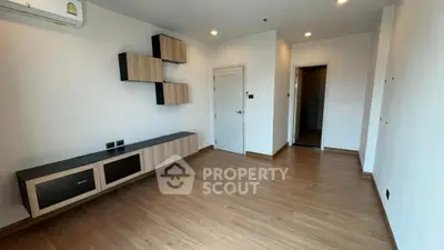 Modern unfurnished living room with wooden flooring and wall-mounted storage units