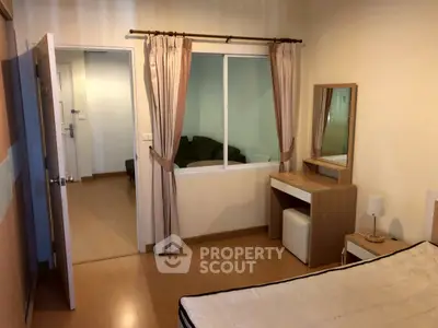 Cozy bedroom with wooden flooring and a small vanity, perfect for modern living.