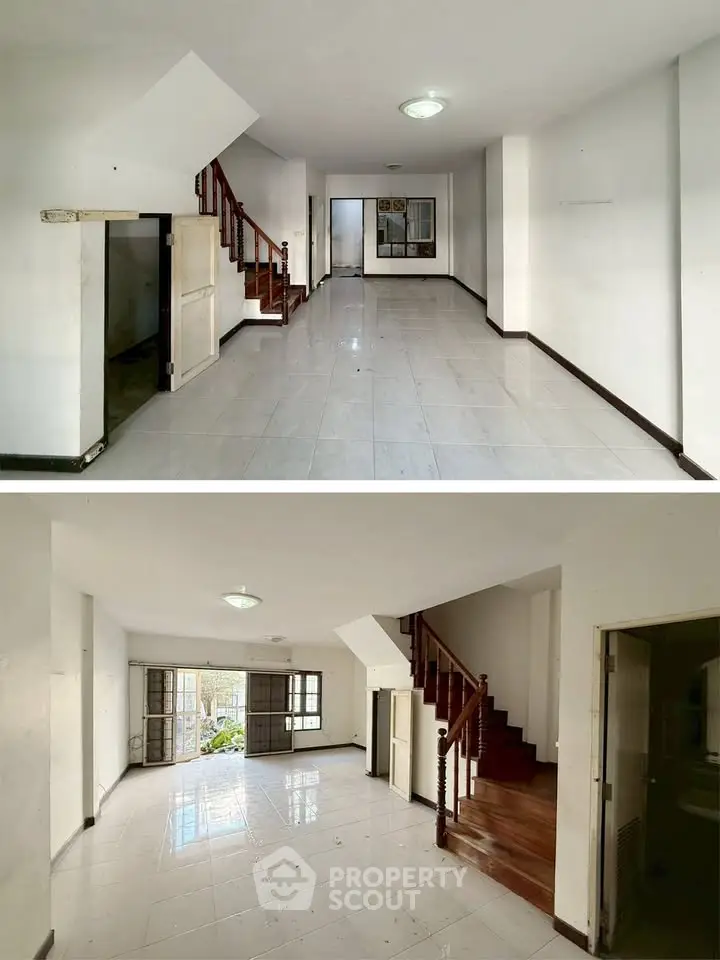 Spacious two-story living area with staircase and large windows, perfect for modern family living.