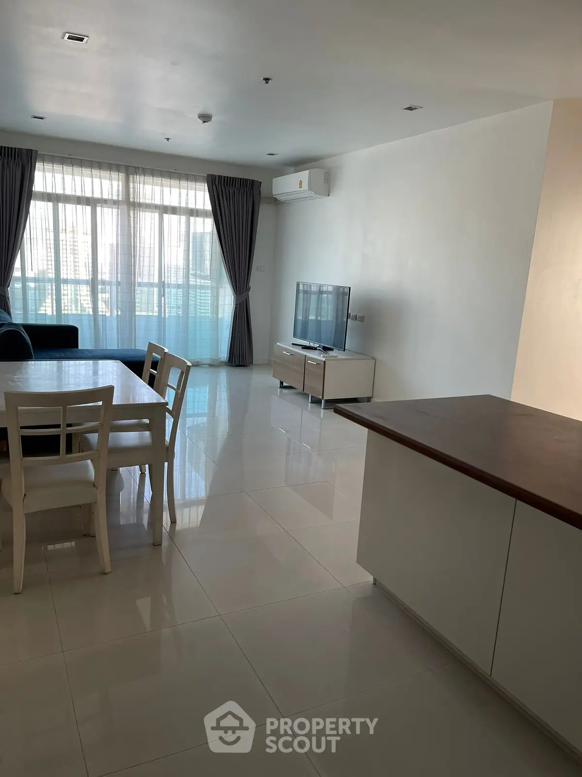 Spacious modern living room with large windows and elegant dining area