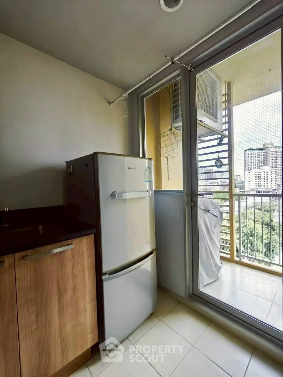 Modern kitchen with fridge and balcony view in urban apartment